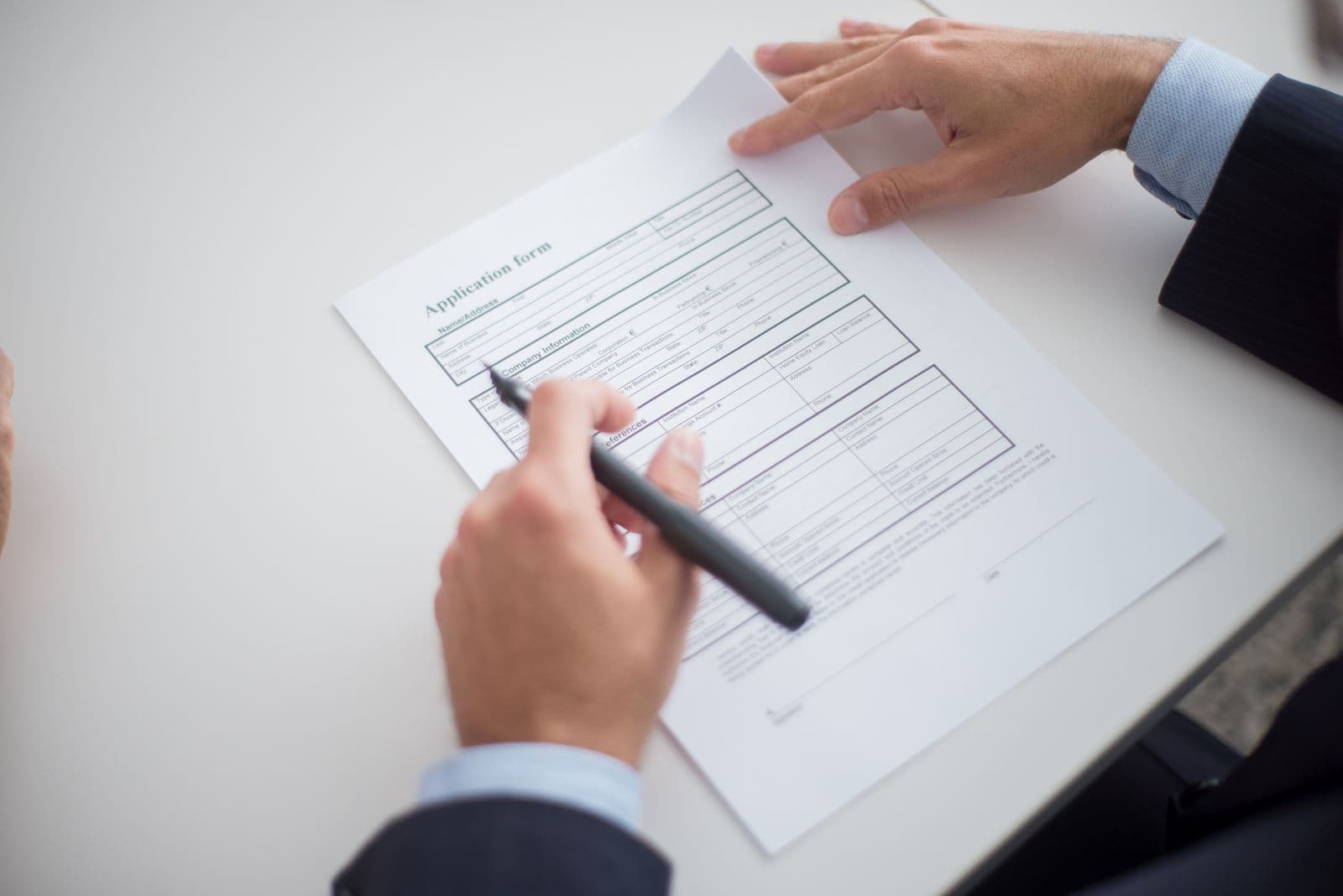 Close-up of a person reviewing an application form at a desk