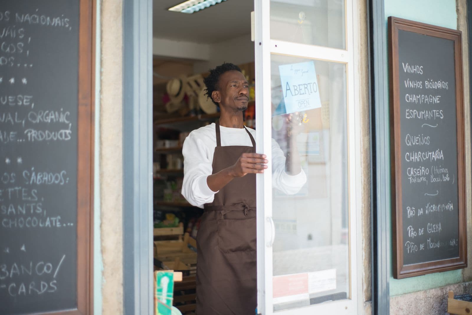 Shop owner in an apron opening the front door of a new store