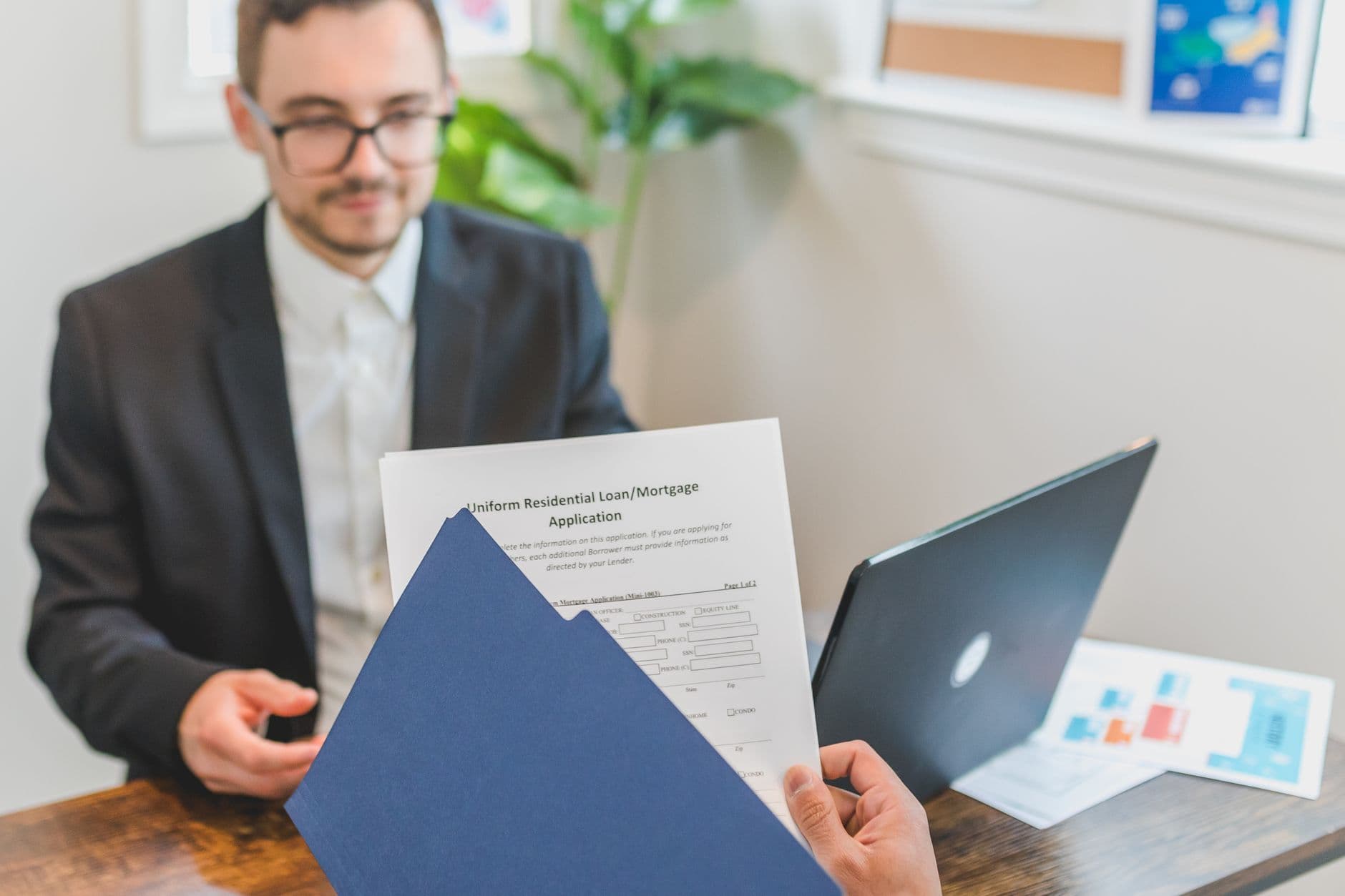 A business owner at a desk going through loan statements and a debt schedule.
